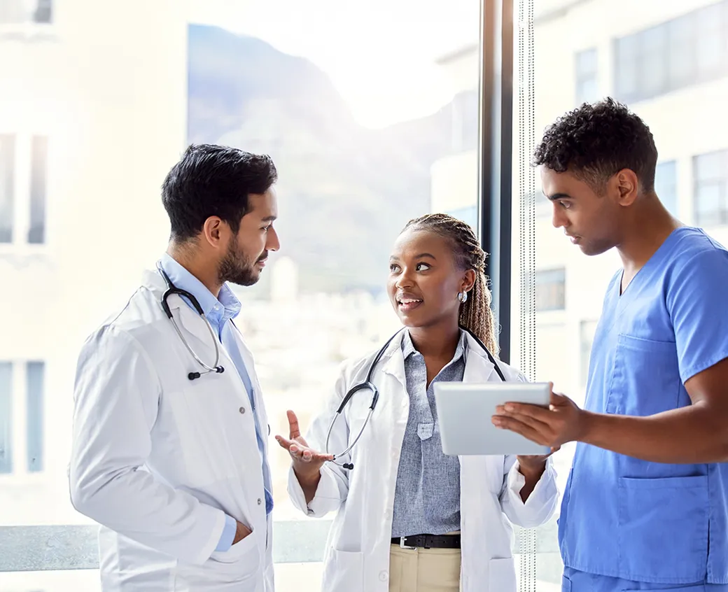 Medical team reviewing patient data on a digital tablet in a clinical setting. Ideal for healthcare, teamwork, and modern medicine concepts.