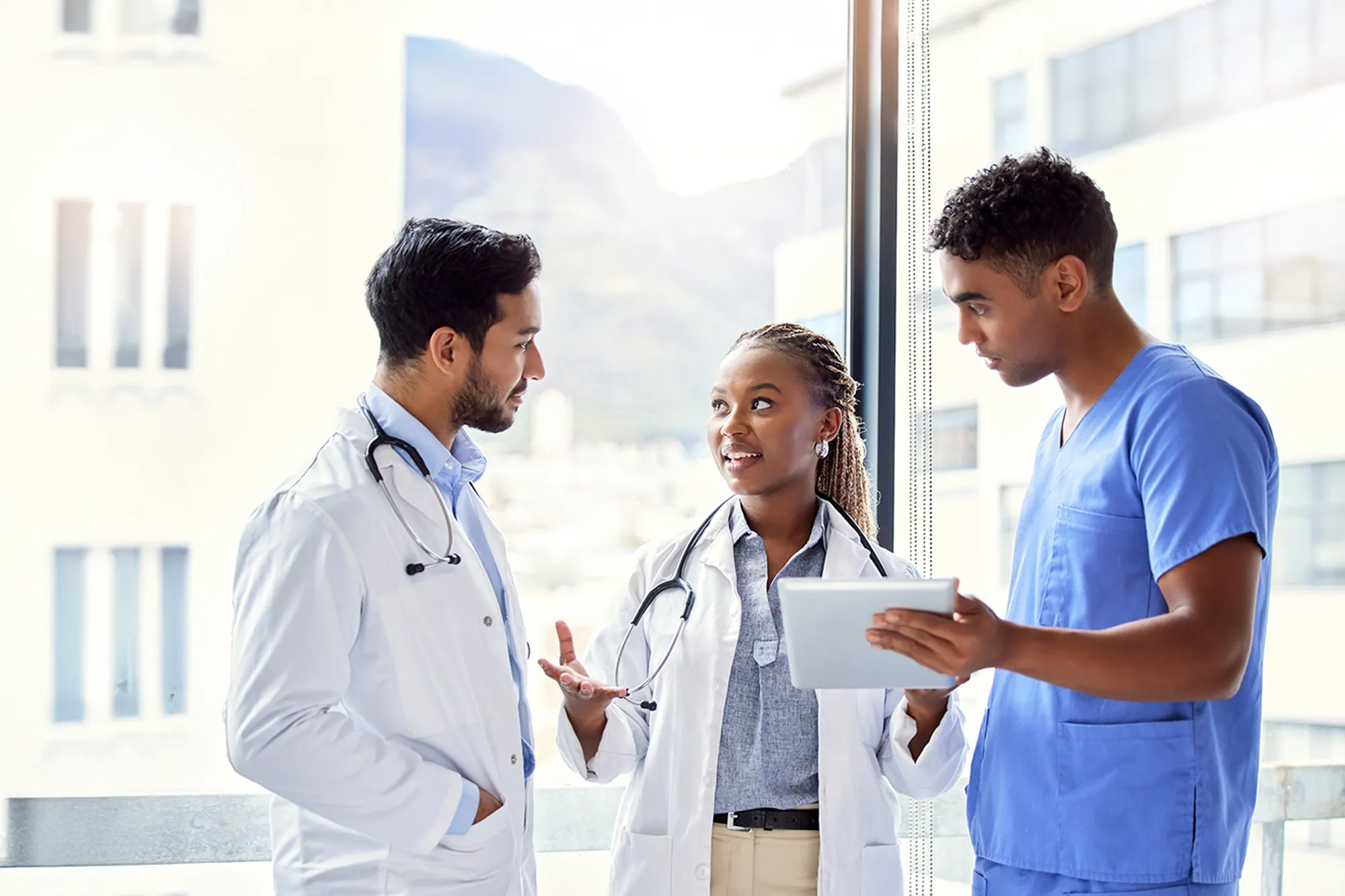 Medical team reviewing patient data on a digital tablet in a clinical setting. Ideal for healthcare, teamwork, and modern medicine concepts.