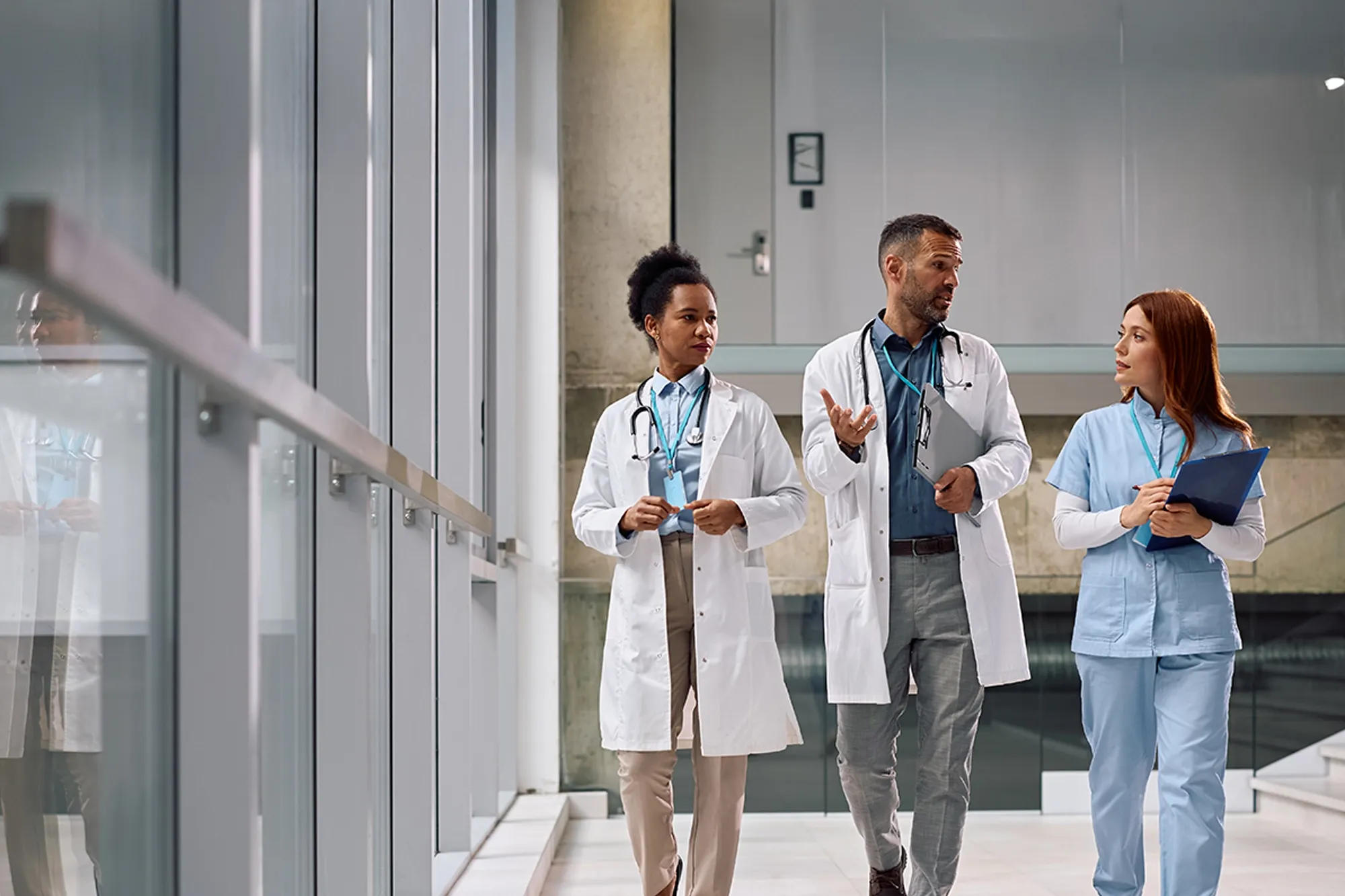 Professional healthcare workers walking and discussing in a hospital corridor. Great for teamwork, medical staff, and hospital care themes.