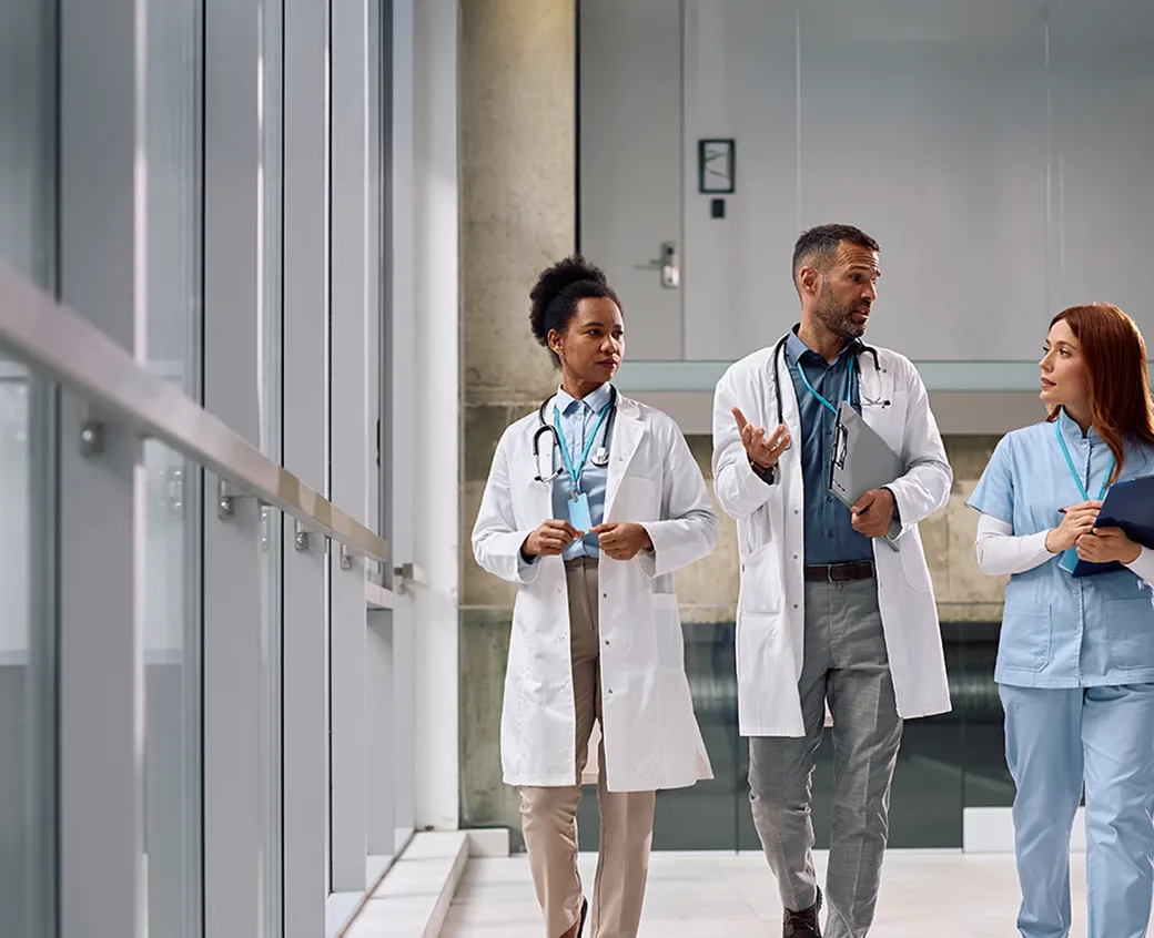 Professional healthcare workers walking and discussing in a hospital corridor. Great for teamwork, medical staff, and hospital care themes.
